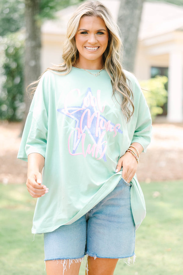 Plus size light sage boyfriend tee with 'Cool Moms Club' graphic and a relaxed, flowy fit.