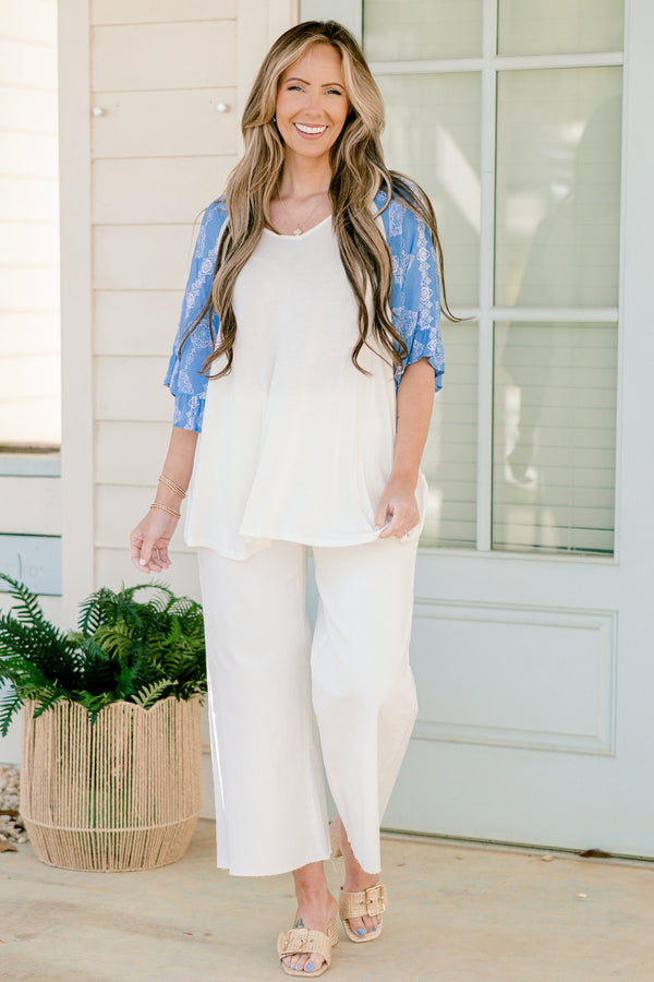 Plus Size white bodice top with blue abstract print raglan sleeves and a scoop neckline.