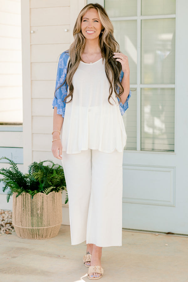 Plus Size white bodice top with blue abstract print raglan sleeves and a scoop neckline.