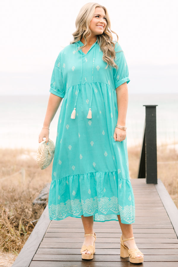 Chic Soul plus size clothing, turquoise tiered maxi dress with short sleeves that have a cuff at the bottom as well as an abstract block pattern throughout the dress and tassels hanging from the v-neckline 
