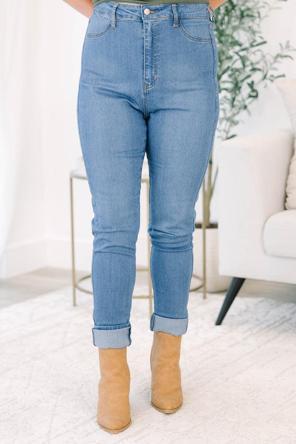 Plus size high-rise skinny jeans in denim blue with cuffed ankles and stretchy fabric.