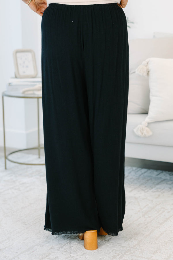 Plus Size black wide-leg pants with an elastic waistband, side pockets, and frayed hem detail.