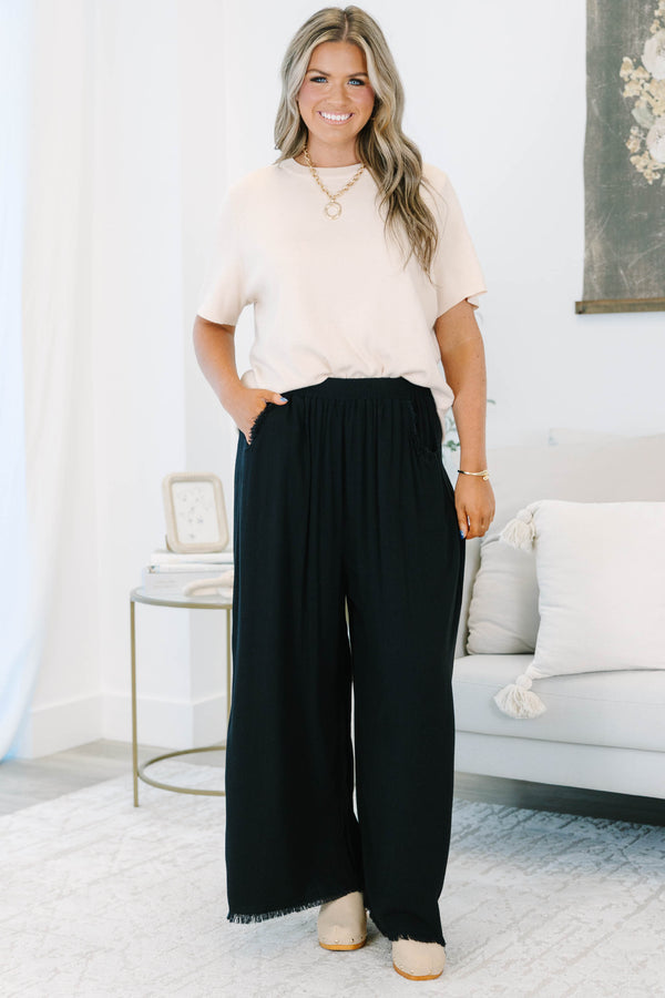 Plus Size black wide-leg pants with an elastic waistband, side pockets, and frayed hem detail.