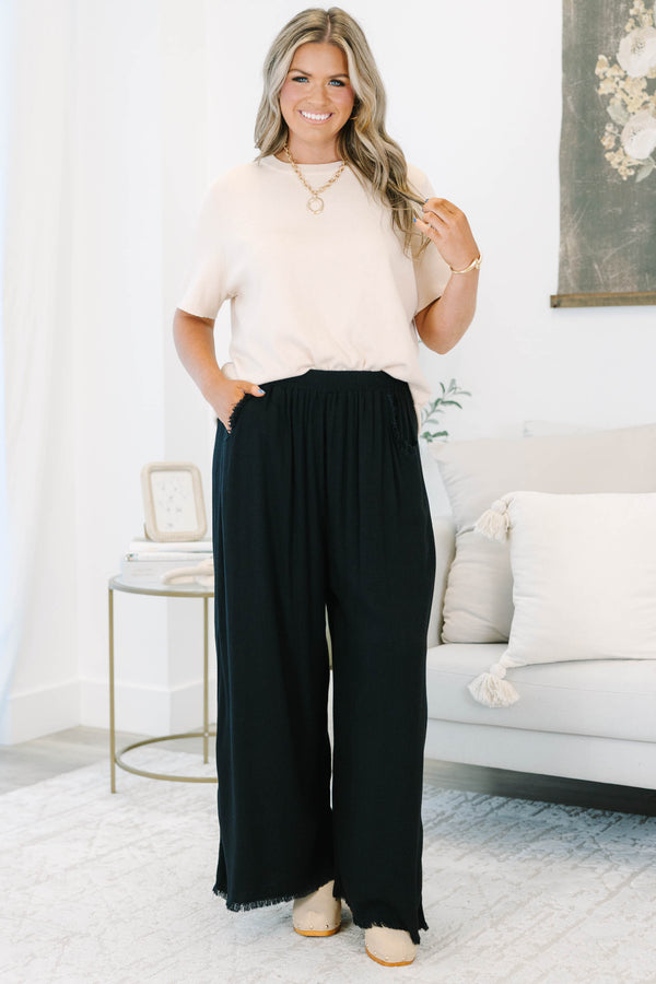 Plus Size black wide-leg pants with an elastic waistband, side pockets, and frayed hem detail.