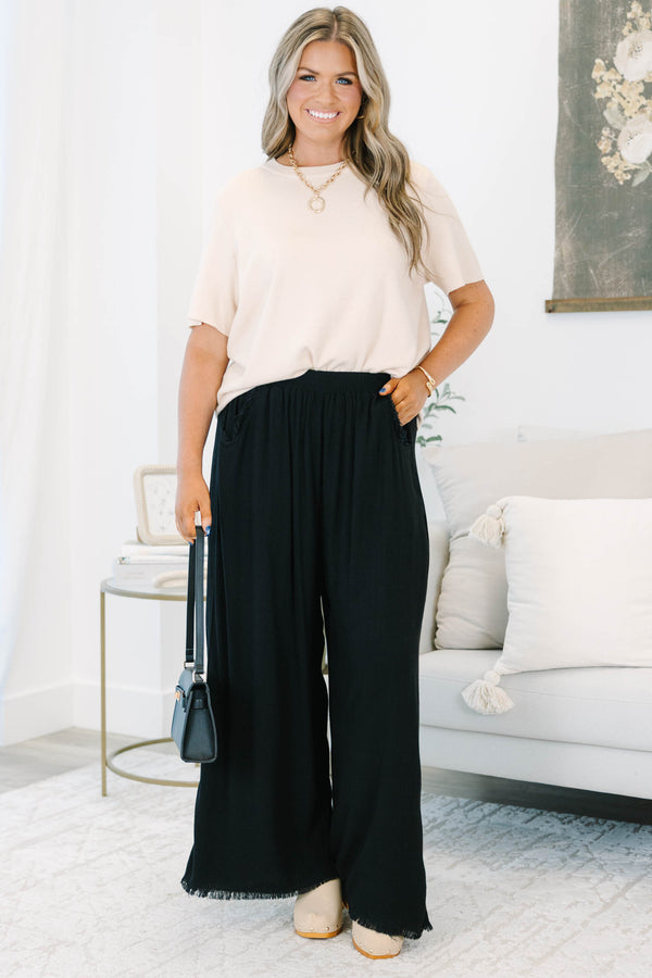 Plus Size black wide-leg pants with an elastic waistband, side pockets, and frayed hem detail.