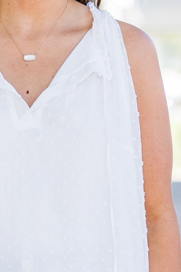 Plus Size white sleeveless swiss dot tank with a split v-neckline, tassels, and ruffled hem.