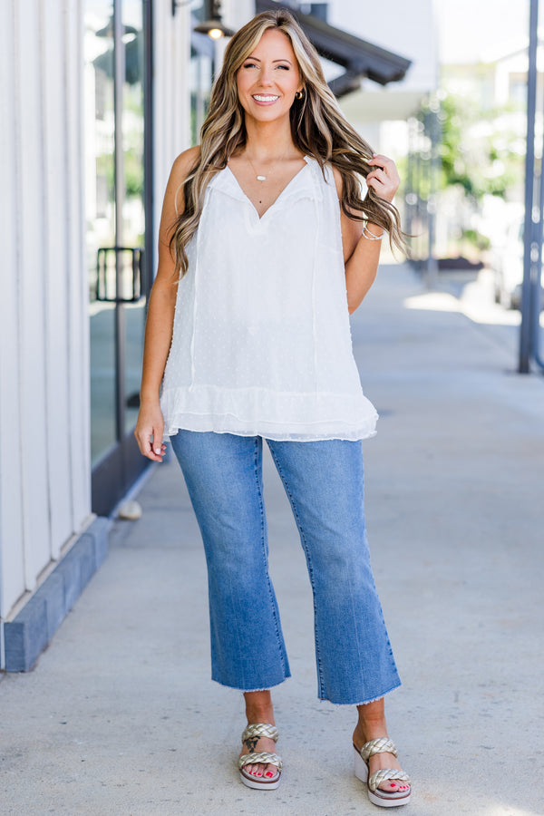 Plus Size white sleeveless swiss dot tank with a split v-neckline, tassels, and ruffled hem.