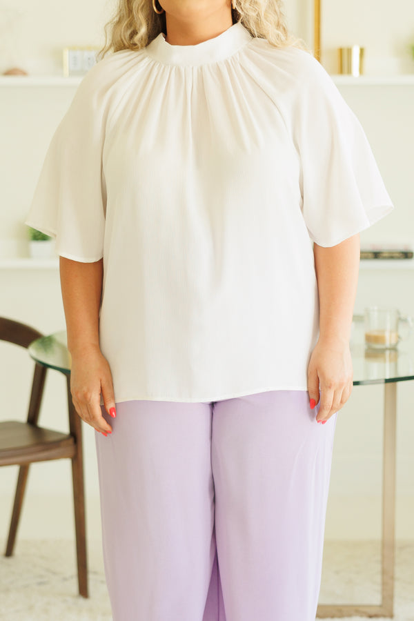 Plus Size white high-neck top with flutter sleeves paired with light purple wide-leg pants.
