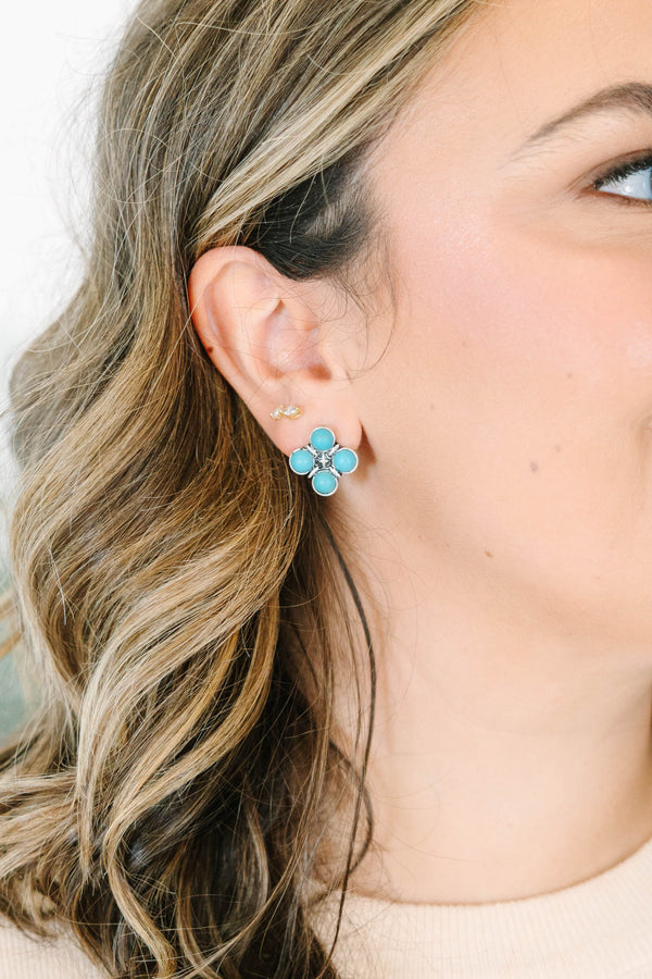 Close-up of a woman wearing The Darling Earrings, featuring four round turquoise stones in silver.