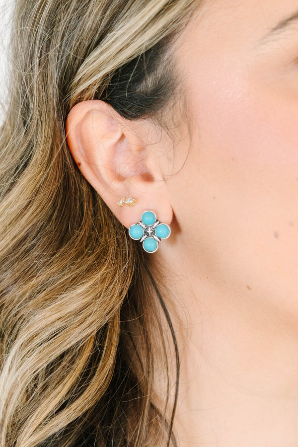 Close-up of a woman wearing The Darling Earrings, featuring four round turquoise stones in silver.