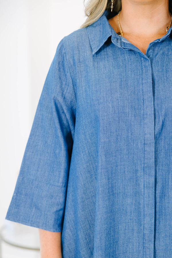 Plus size blue chambray shirt dress with a flowy fit, button placket, and three-quarter sleeves.