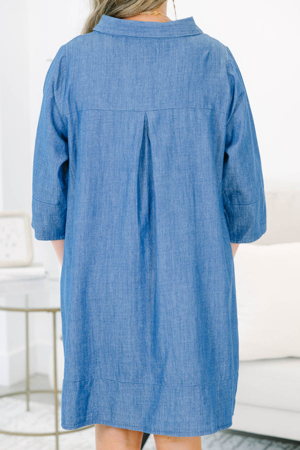 Plus size blue chambray shirt dress with a flowy fit, button placket, and three-quarter sleeves.