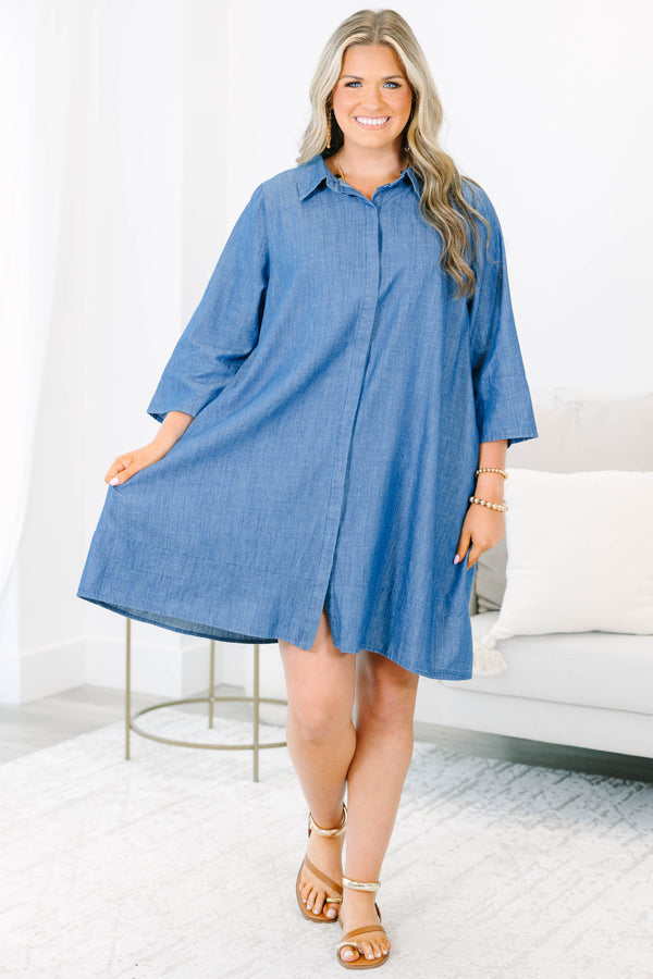 Plus size blue chambray shirt dress with a flowy fit, button placket, and three-quarter sleeves.