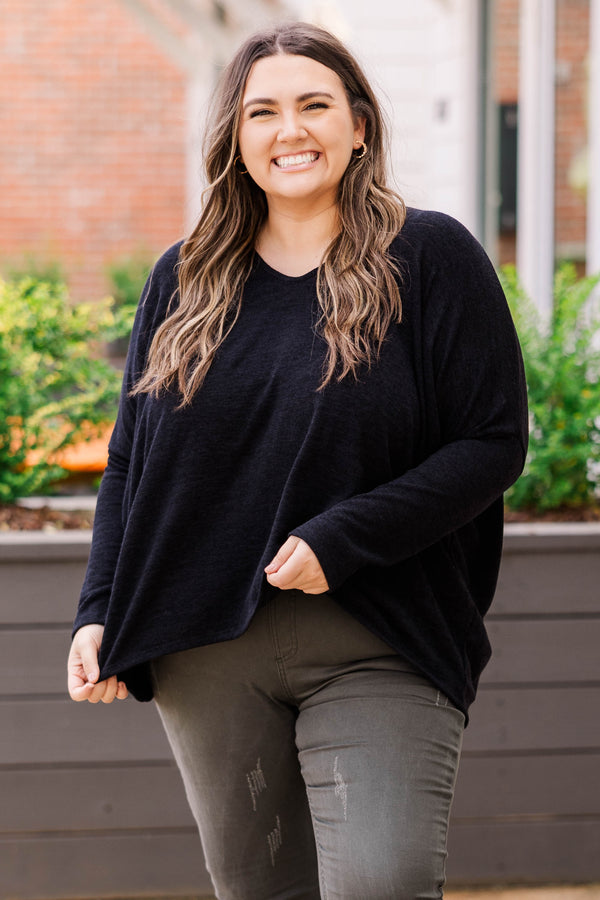 Plus Size long sleeve black top with a v-neckline and a relaxed, oversized fit.