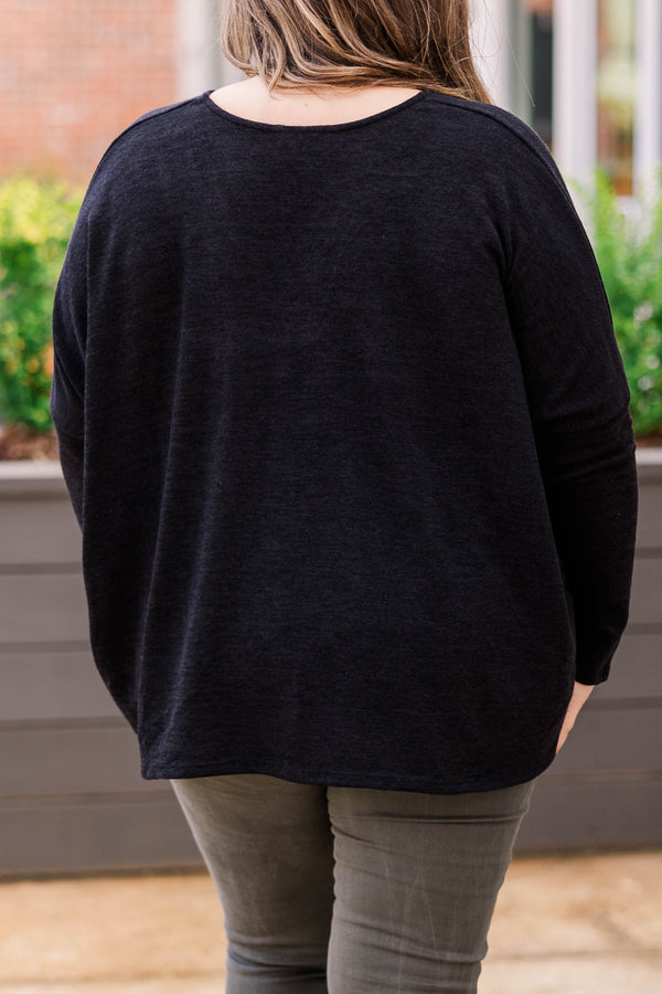 Plus Size long sleeve black top with a v-neckline and a relaxed, oversized fit.