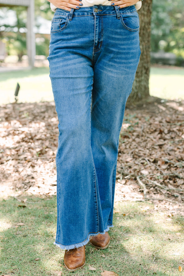 Plus size medium wash flare jeans with a raw hem and stretchy denim for a confident, flowy fit.