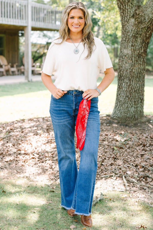Plus size medium wash flare jeans with a raw hem and stretchy denim for a confident, flowy fit.