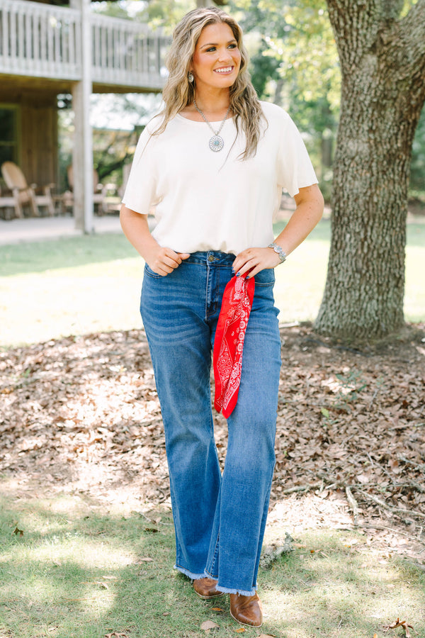 Plus size medium wash flare jeans with a raw hem and stretchy denim for a confident, flowy fit.