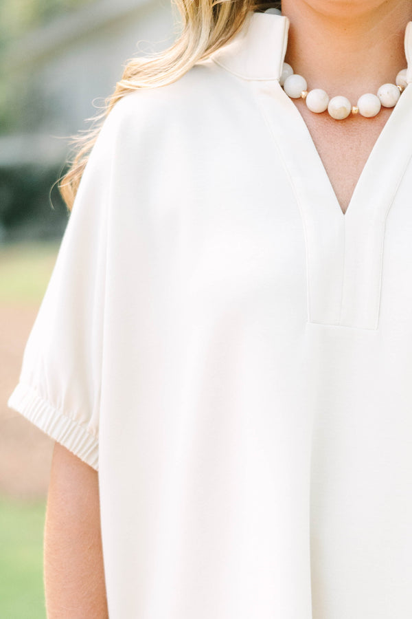 Plus Size beige short sleeve top with a V-neckline and elasticized puff sleeves.