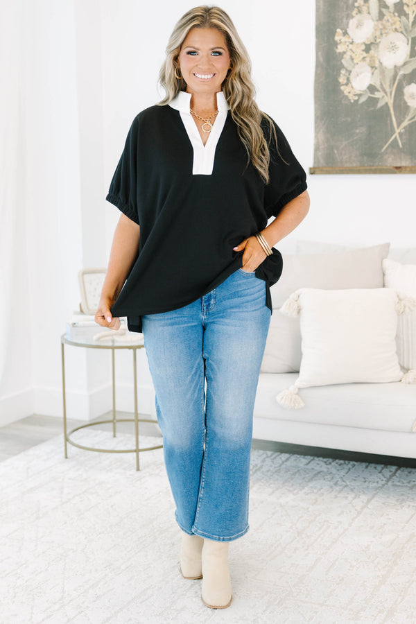 Plus size black top with a white v-neck collar, flowy fit, and short puff sleeves.