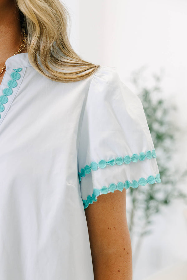 Plus size blue cotton top with split v-neck, flutter sleeves, and teal polka dot trim detailing.