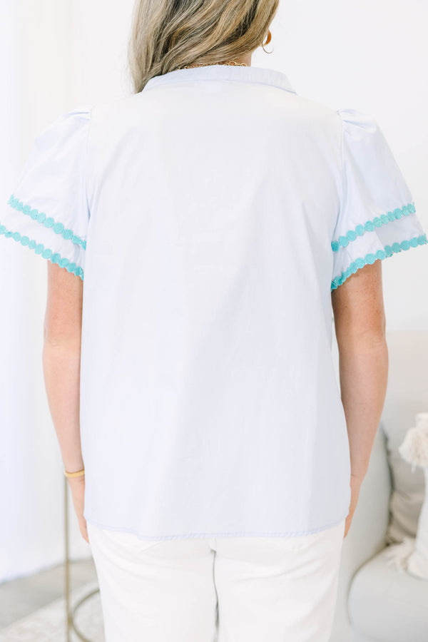 Plus size blue cotton top with split v-neck, flutter sleeves, and teal polka dot trim detailing.