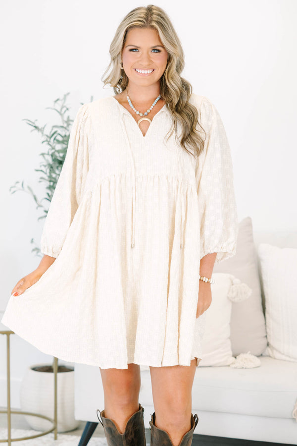 Plus Size cream babydoll dress with a V-neckline, tassel ties, and long balloon sleeves.