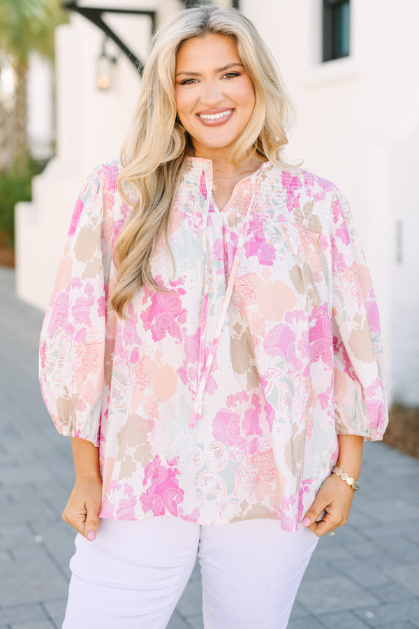 Chic Soul plus size clothing, pink top with half bubble sleeves a multi colored pink watercolor floral pattern as well as a smocked texture on the top of the chest and a slight v-neckline 
