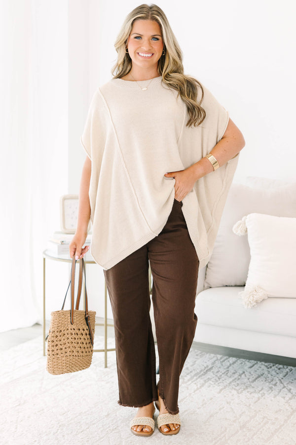 Plus size dark brown wide leg jeans with a raw hem and stretchy cotton fabric.