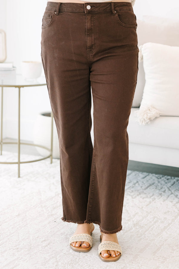 Plus size dark brown wide leg jeans with a raw hem and stretchy cotton fabric.