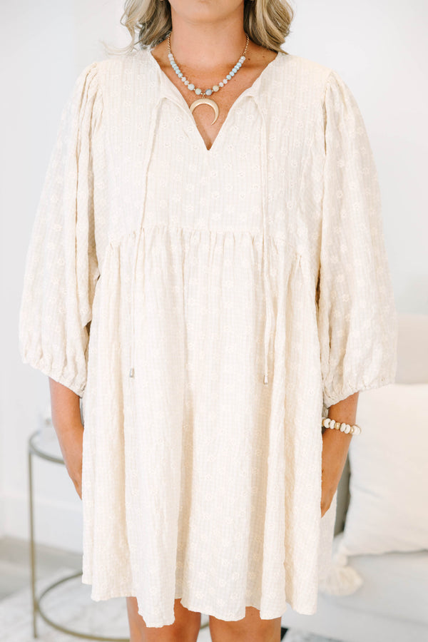 Plus Size cream babydoll dress with a V-neckline, tassel ties, and long balloon sleeves.