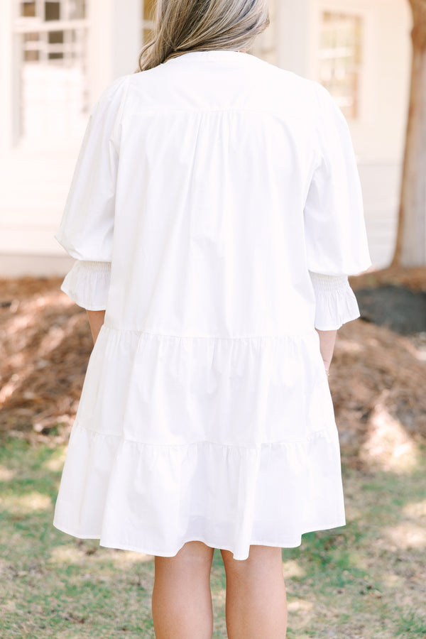Plus Size white babydoll dress with a split v-neck, smocked cuffs, and mini bell sleeves.
