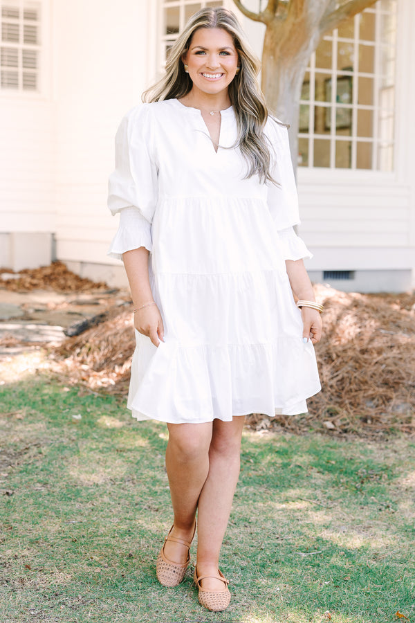 Plus Size white babydoll dress with a split v-neck, smocked cuffs, and mini bell sleeves.
