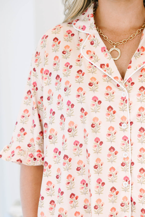 Plus Size cream floral pajama set with a button-down short sleeve top and matching ruffled shorts.