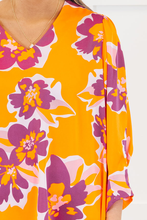 Plus Size orange V-neck top with a bold purple and pink floral print and long sleeves.