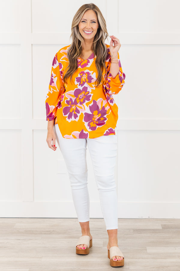 Plus Size orange V-neck top with a bold purple and pink floral print and long sleeves.