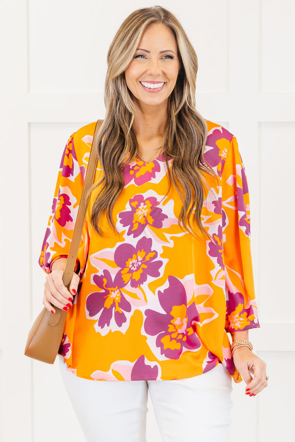 Plus Size orange V-neck top with a bold purple and pink floral print and long sleeves.