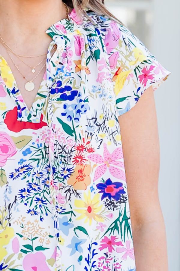 Chic Soul plus size clothing, off white short sleeve top with v cutout on neckline with tie detailing and multicolored floral print