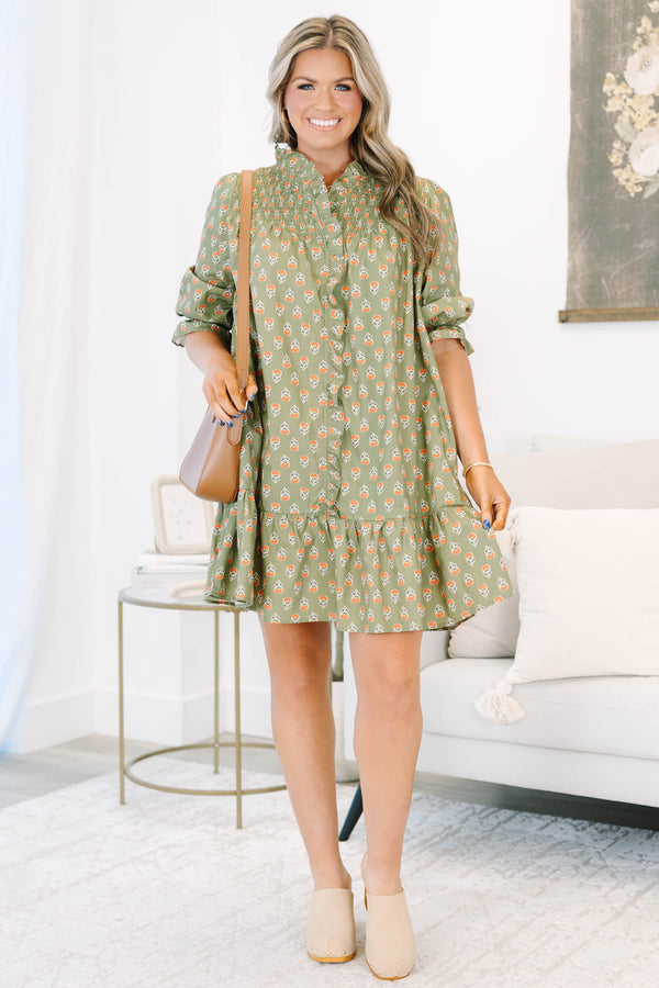 Plus size olive green floral mini dress with a flowy fit, smocked bodice, and ruffle details.