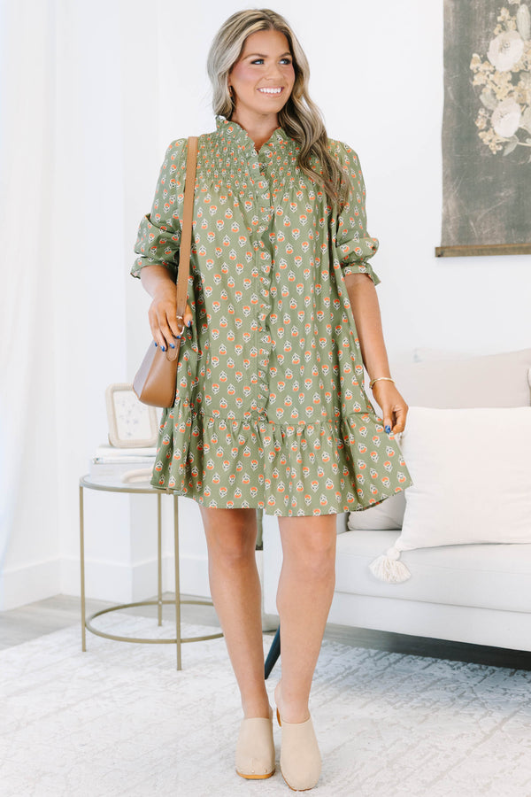 Plus size olive green floral mini dress with a flowy fit, smocked bodice, and ruffle details.
