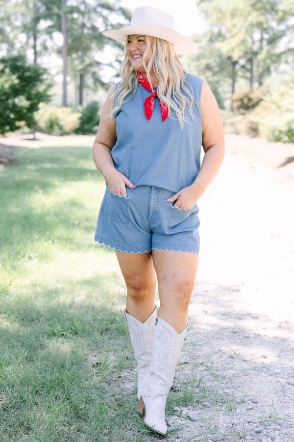 Plus Size denim shorts with white scalloped trim on the pockets and hem, paired with white boots.