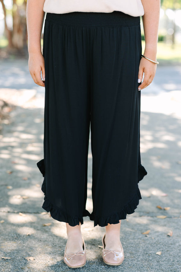 Plus Size black wide-leg rayon pants with a smocked waistband and ruffled hem.