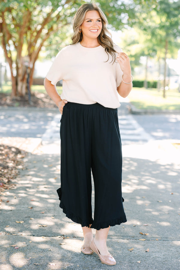 Plus Size black wide-leg rayon pants with a smocked waistband and ruffled hem.