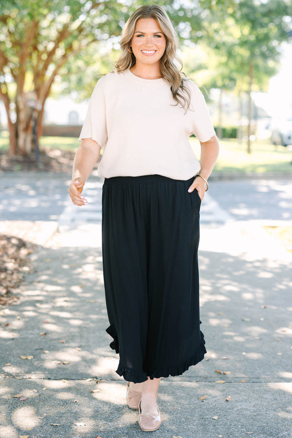 Plus Size black wide-leg rayon pants with a smocked waistband and ruffled hem.