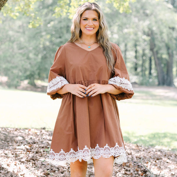 Plus size brown babydoll mini dress with puff sleeves and white crochet lace trim on hem and cuffs.