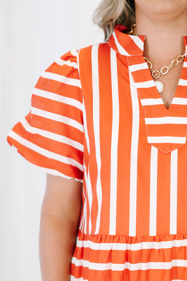 Plus size orange and white striped tiered maxi dress with puff sleeves and a flowy fit.