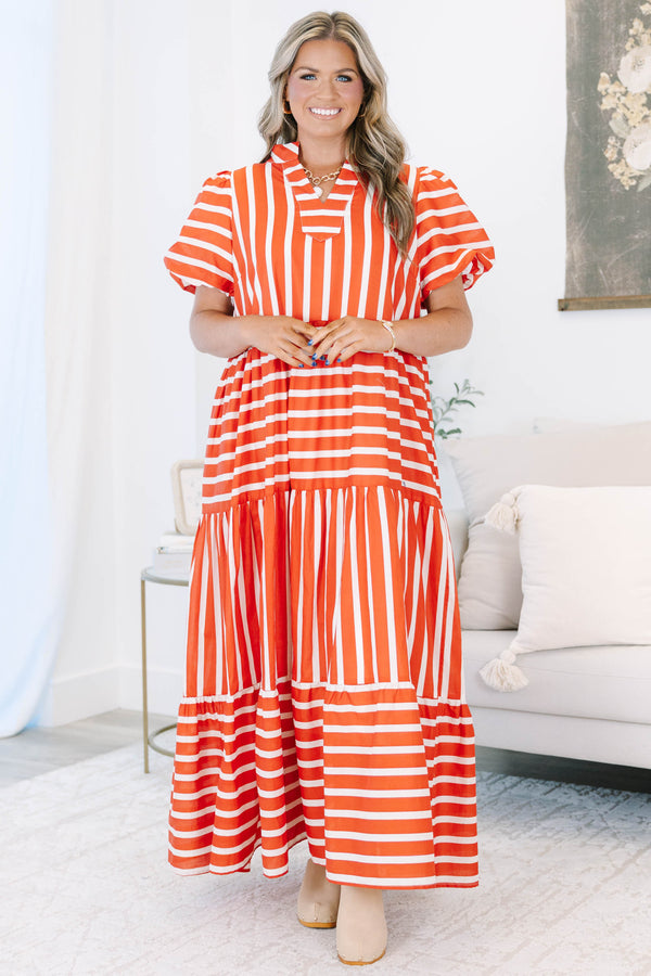 Plus size orange and white striped tiered maxi dress with puff sleeves and a flowy fit.