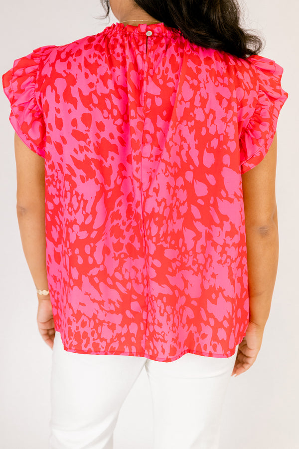 Chic Soul plus size clothing, fuchsia top with a high neck that has ruffle detailing as well as flutter sleeves and a pink abstract pattern throughout 