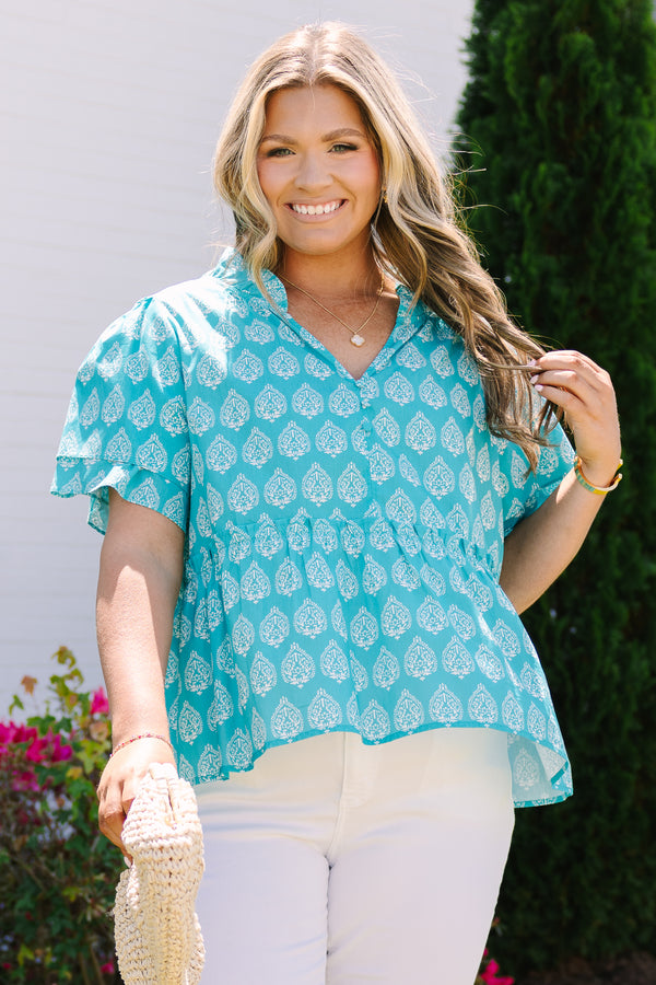 Chic Soul plus size clothing, teal top with short sleeves that have a ruffle flare on the ends of the sleeves as well as a slight v-neckline and an abstract white block pattern throughout 
