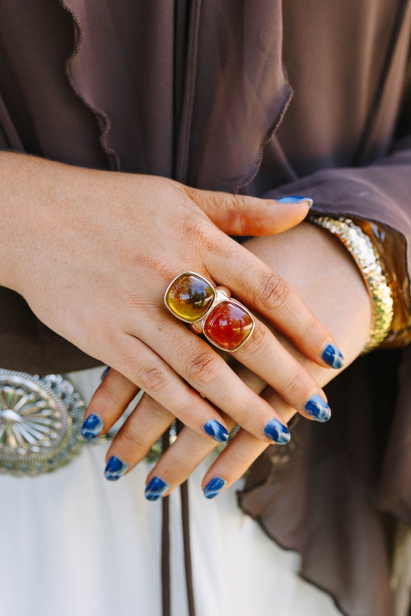 Cowgirl Charm Ring in brown and amber tones on a model with blue nails and western accessories.